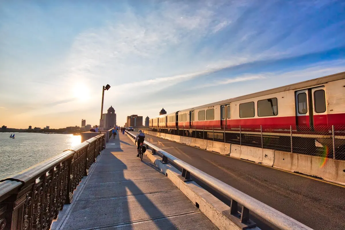 MBTA Red Line subway train crossing the Longfellow Bridge over the Charles River at sunset in Boston, Massachusetts