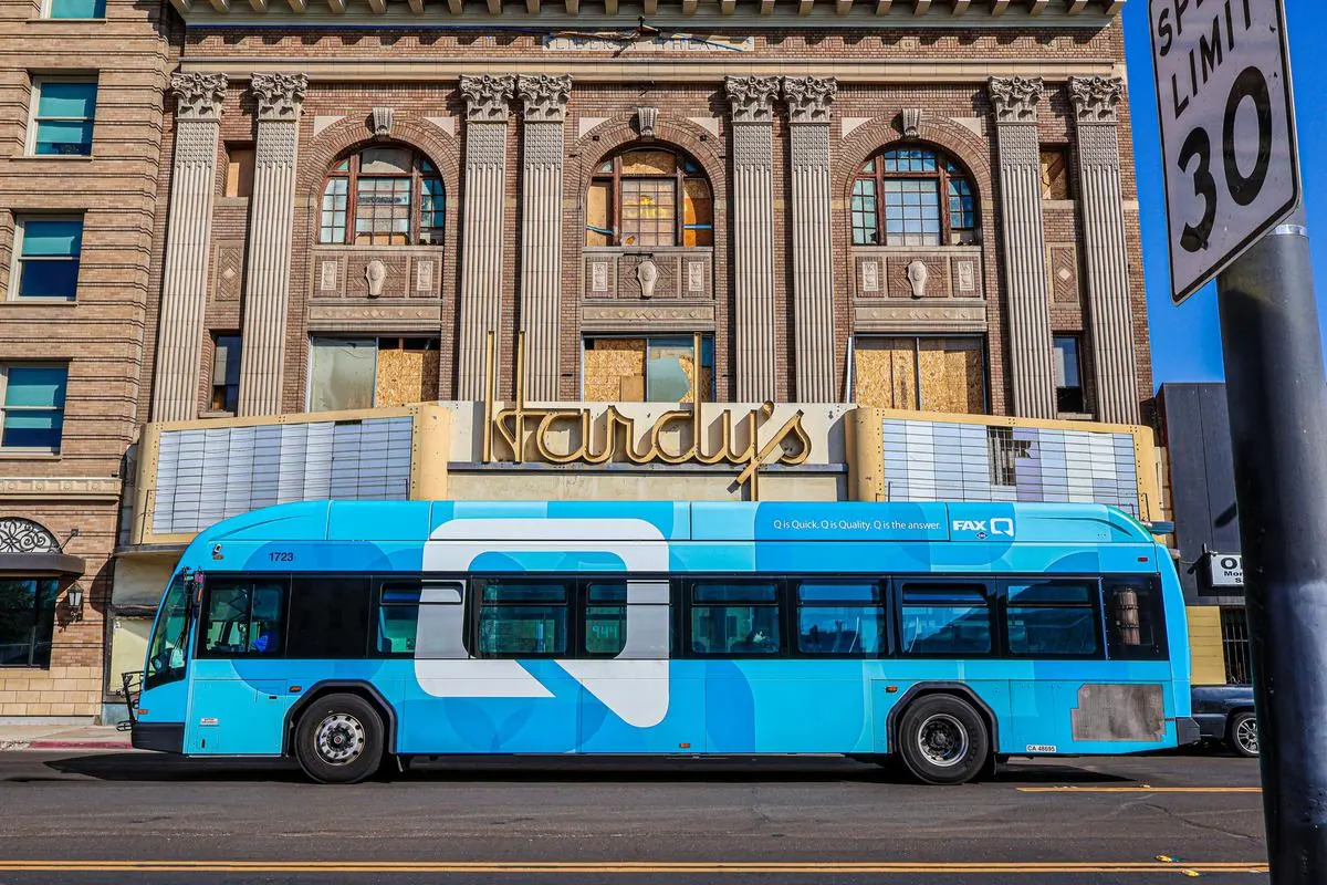City bus stopped at a red light in front of a building in downtown Fresno, California
